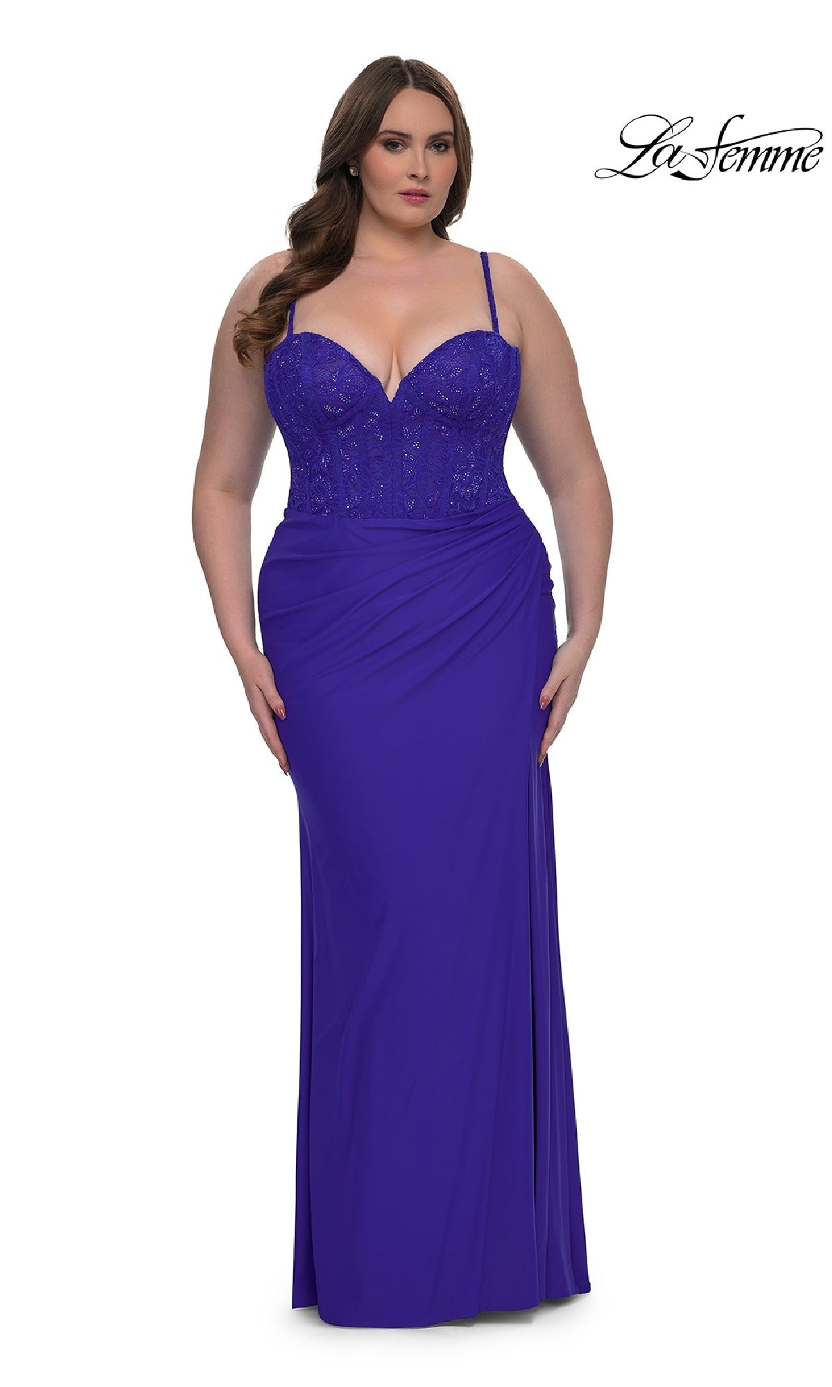 A woman wears the Plus-Size Long Corset Prom Dress La Femme 32449, a fitted royal blue gown with thin straps and beaded bodice detailing, standing against a white background.